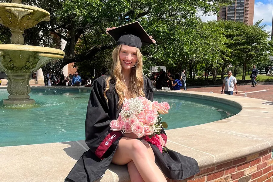 ̽¥ student Brooke Speights stands outside in her graduation attire
