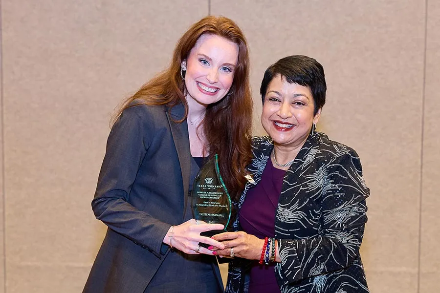 TWU graduate student Tristen Marshall stands next to Dean Yelkur holding an award