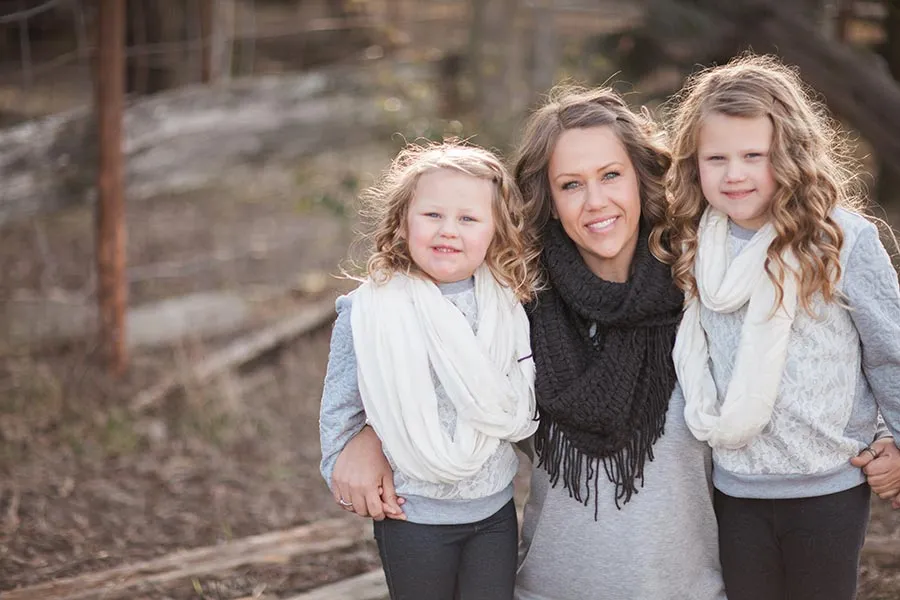 Lauren Houser crouches in middle, surrounded by two young daughters