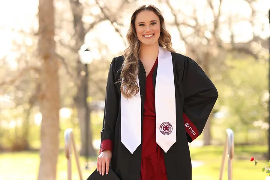 Madison Treu in her cap and gown on the TWU Denton campus.