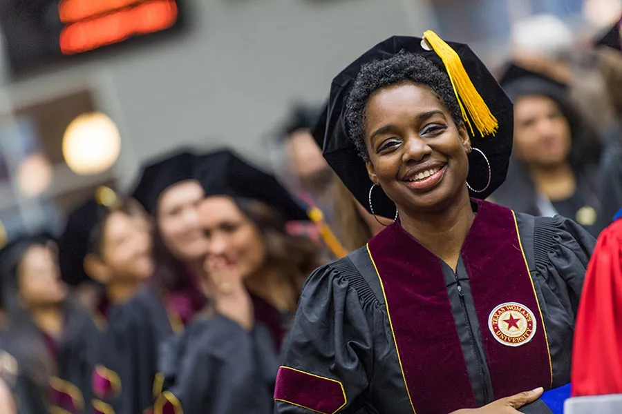 A graduate student in a tam and gown at Commencement