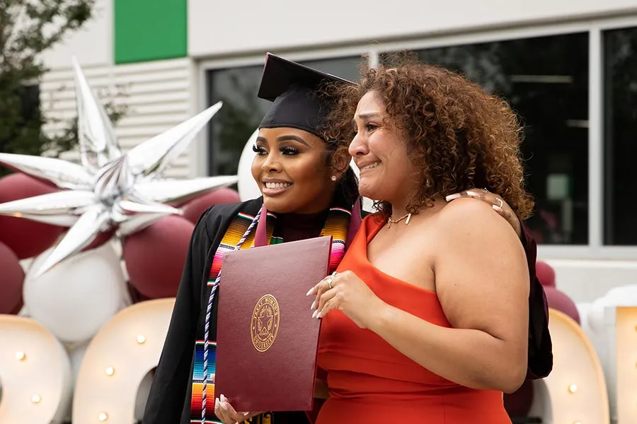 A TWU Houston graduate poses with a family member for photos