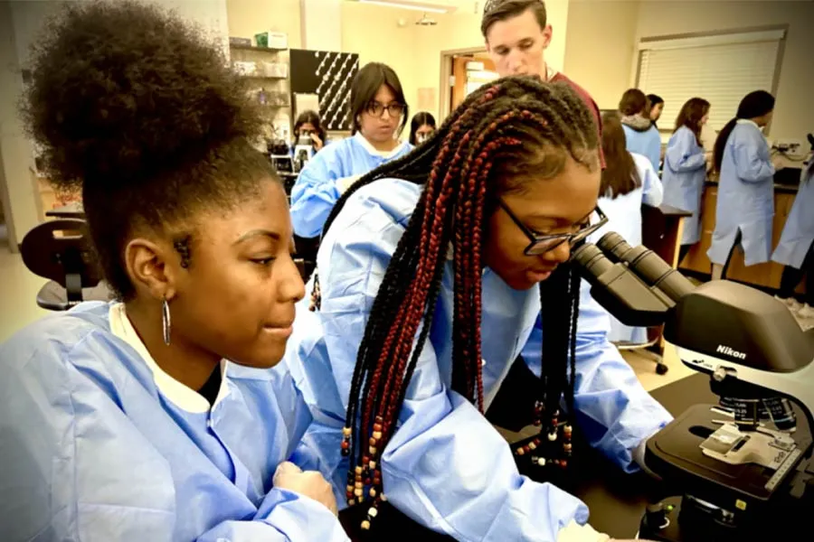 two students using a microscope 