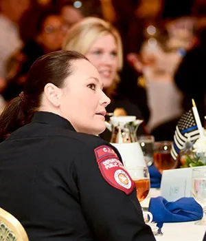 A female police officer sitting a table looking to the right