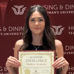 Student Alvarado Mallory holding Academic Excellence award.
