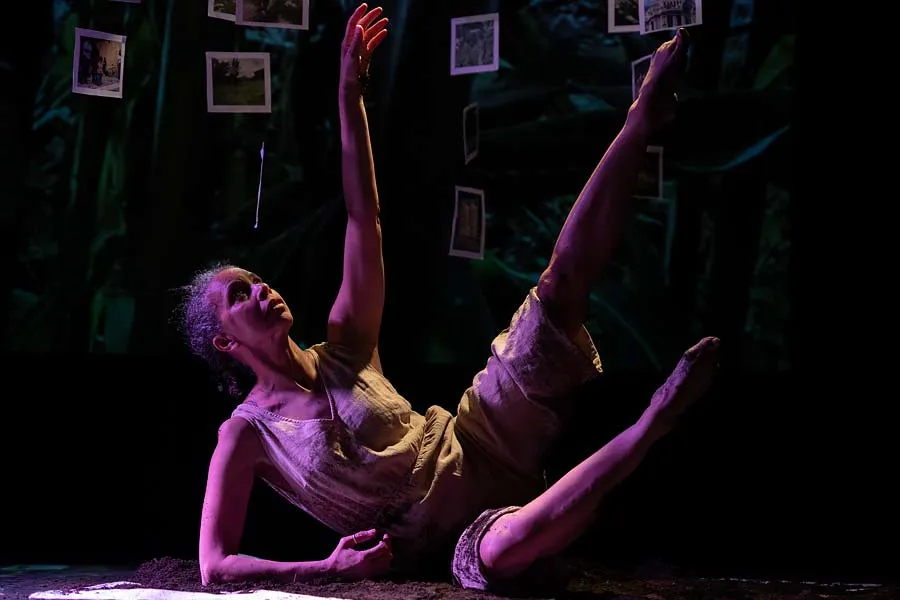 A dancer raises her arms and legs from the floor
