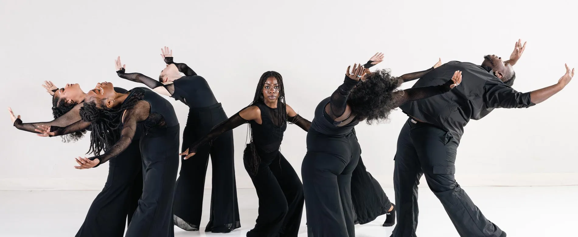 Seven dancers dressed in black