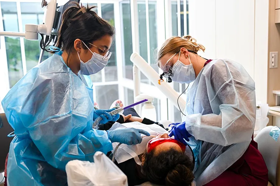 two TWU dental hygiene students inspect a patients teeth in new clinic 