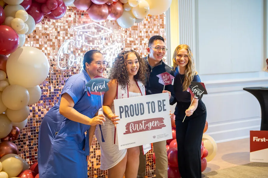 Students at First Generation graduation reception holding a sign