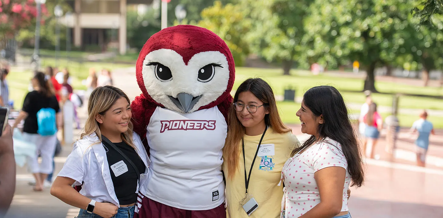 Three TWU students with mascot Oakley