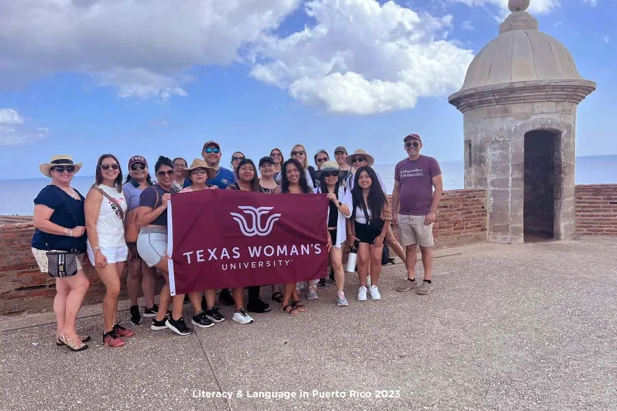 Literacy & Language in Puerto Rico 2023 holding up TWU flag