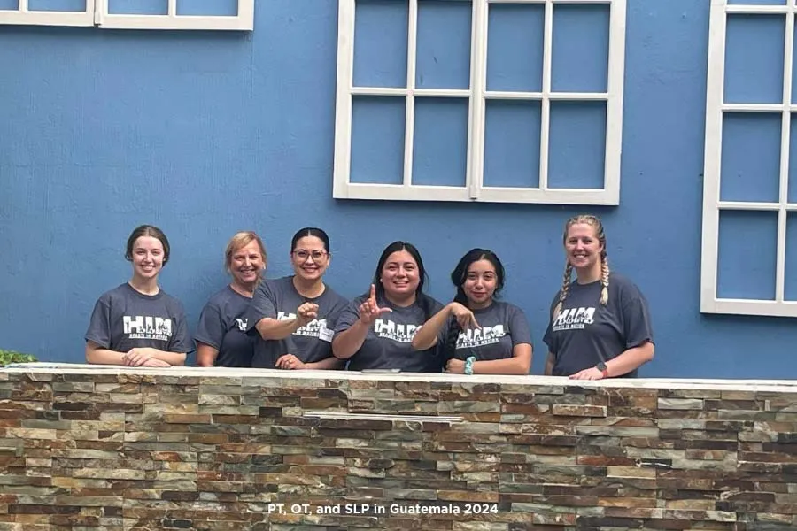 PT, OT and SLP in Guatemala 2024 with SLP students signing 'S-L-P' in American Sign Language