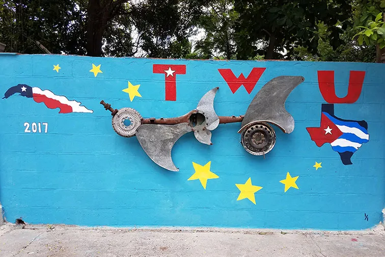 A mural along a brick wall featuring TWU in Cuba