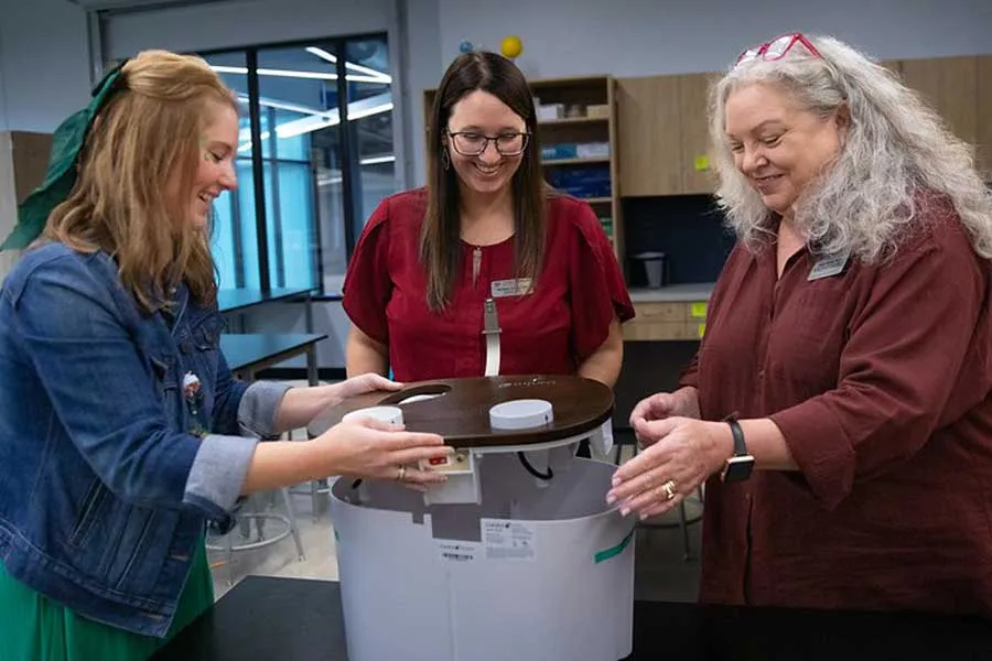 Diana Elrod, PhD, and Michaine Ashley, PhD, help Hill Elementary principal Kascie Blough assemble a hydroponic garden tower