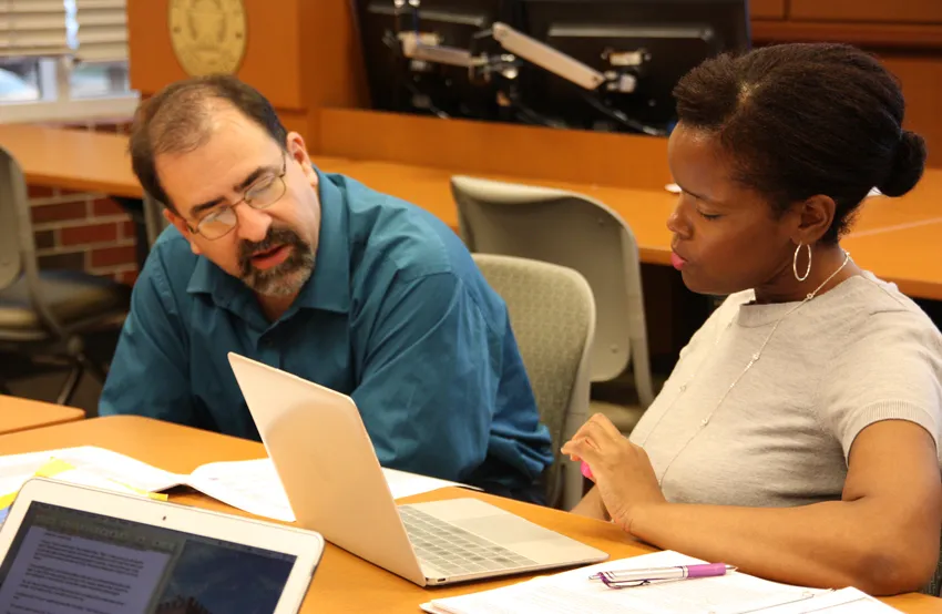 Assistant professor Gray Scott, Ph.D., works with a graduate student during a rhetoric class. 