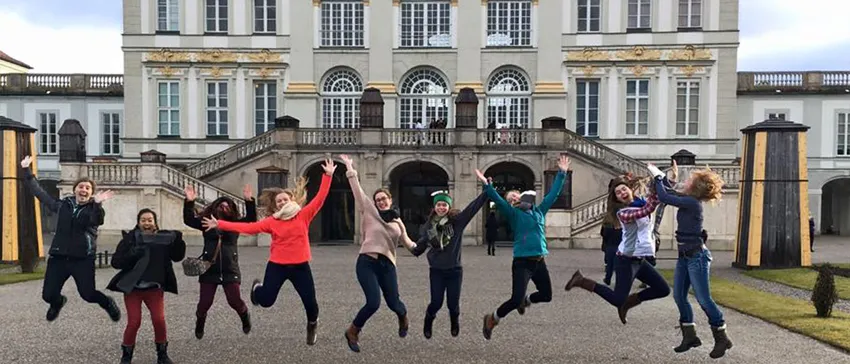 A group of ESFL students jump in front of Schönbrunn Palace. 