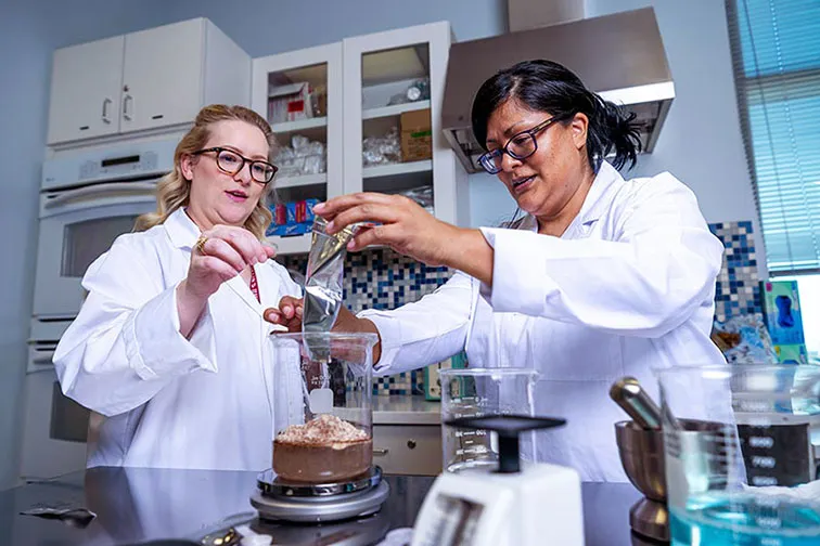 TWU Nutrition & Food Science faculty carefully weigh ingredients in a cooking lab