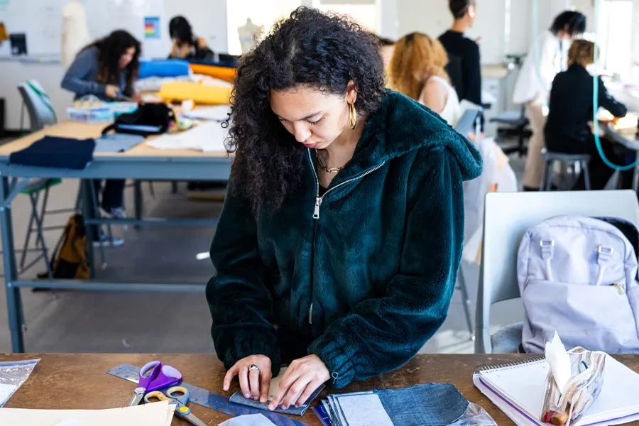 Trinity Mendez-Alston works on garments 