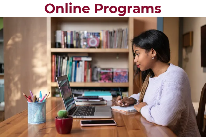A students sits at a computer to attend a lecture or meeting.