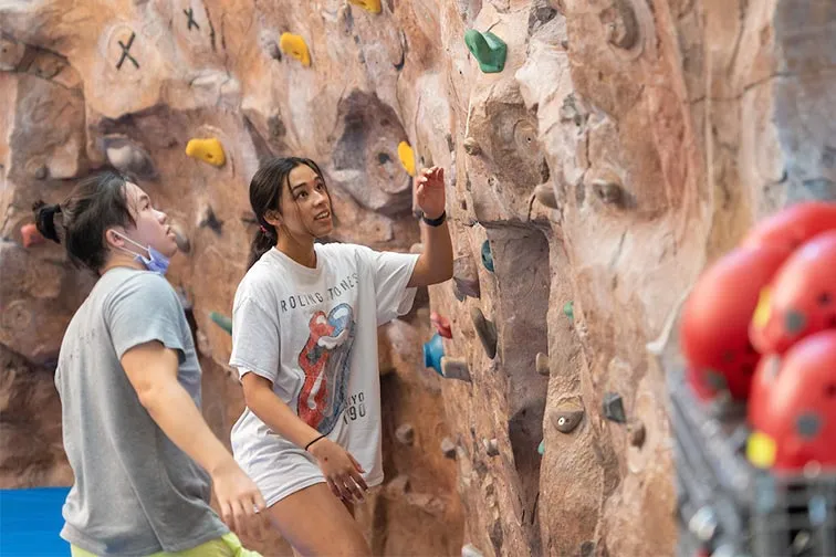 TWU Denton students prepare to climb the wall in the fitness center