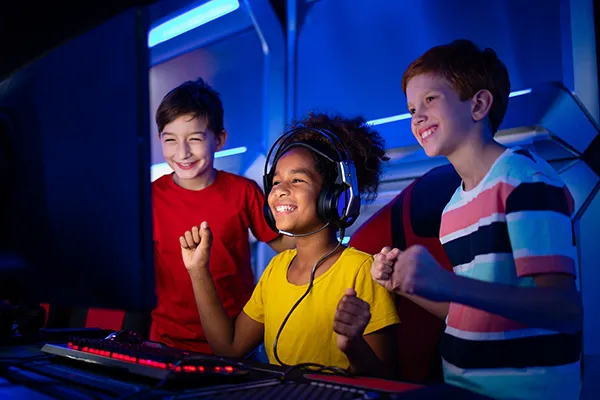 Elementary school children smiling and playing a video game