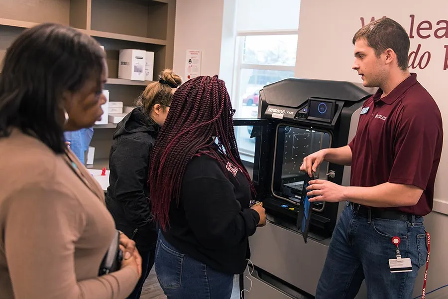 Students are shown how to use a 3D printer