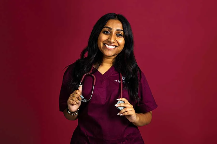 A dramatic portrait of a TWU student in scrubs and holding a stethscope.
