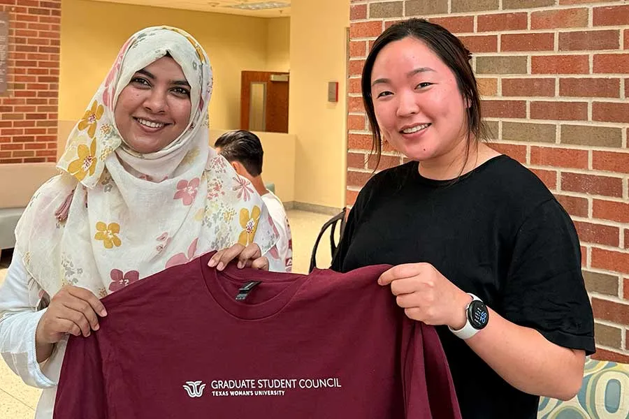 Two Graduate Students holding T-shirt