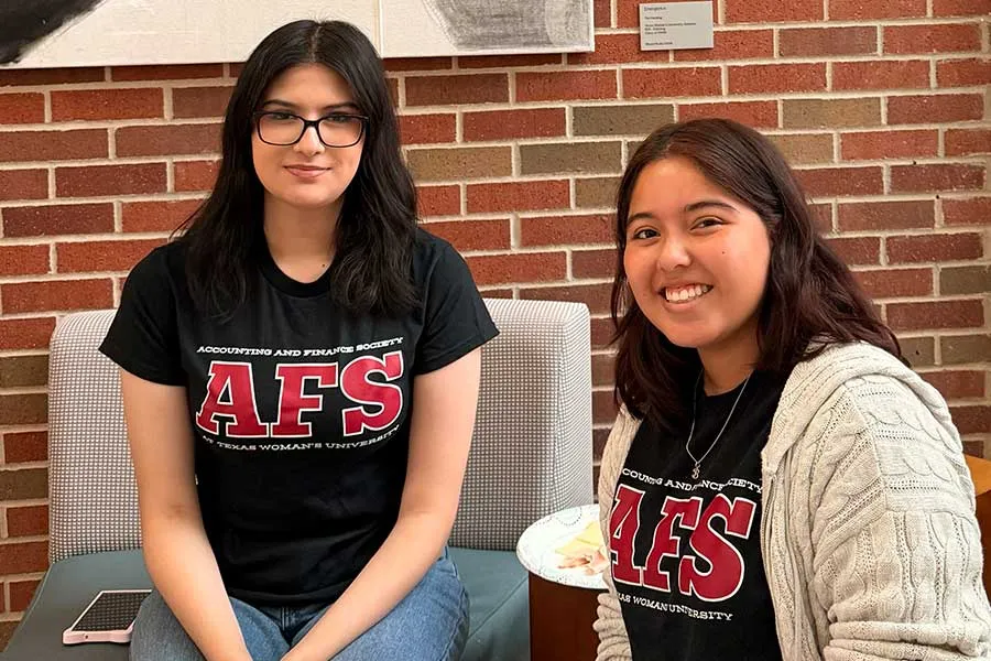 Two Graduate students sitting posing for photo