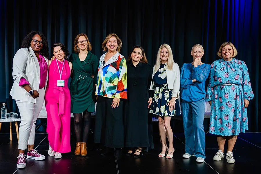 MHA/MBA student Jessica Brown (sixth from left) stands with eight women on a stage