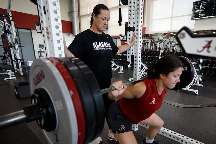 Michelle Diltz stands behind an athlete, spotting on backpress