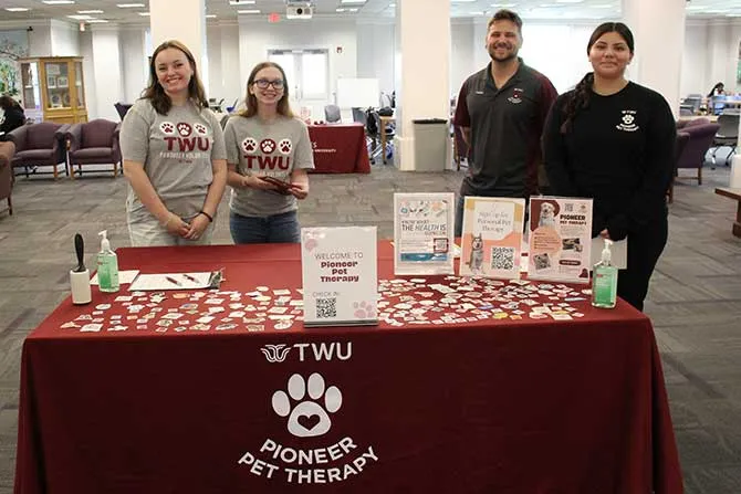 Four people standing behind a table