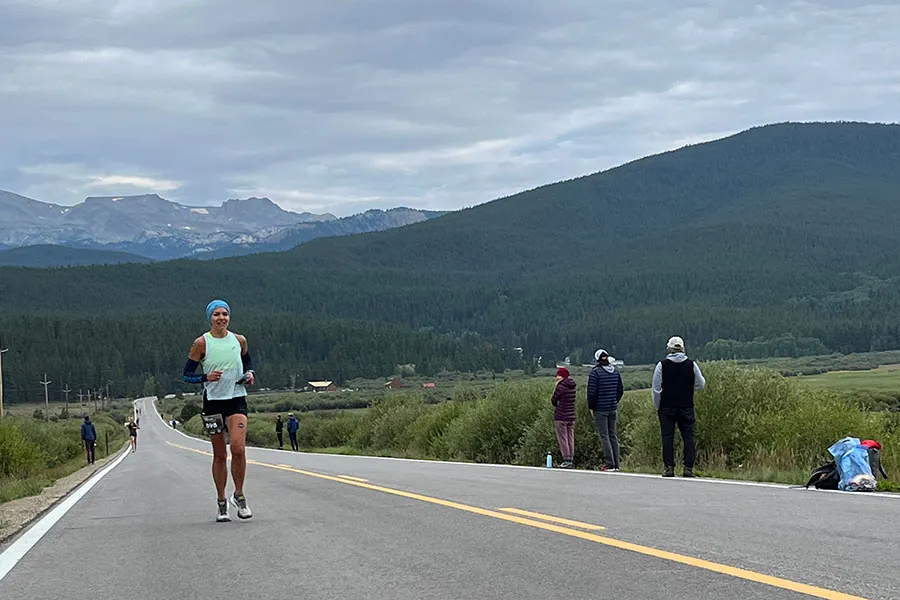 runner runs on road in front of mountains