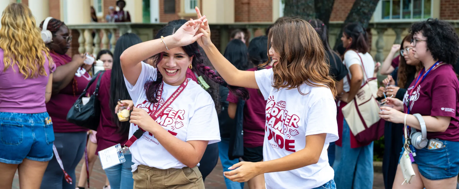 Attendees of the TWU Block Party laugh and dance amidst a bustling crowd of Pioneers.