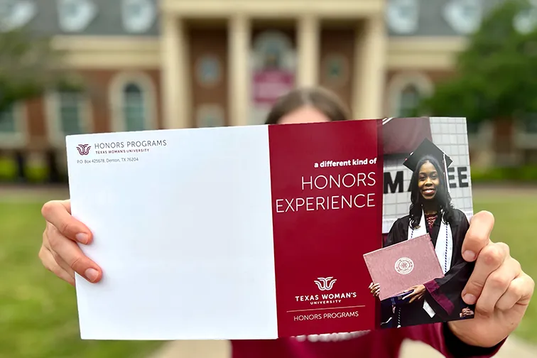 A TWU Honors student reading a brochure