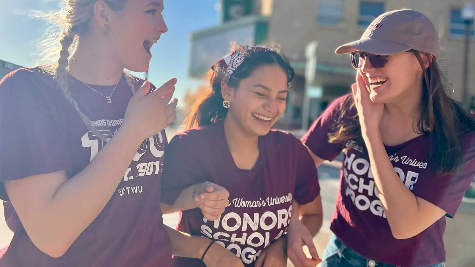 A group of TWU students laughing while walking in downtown Denton