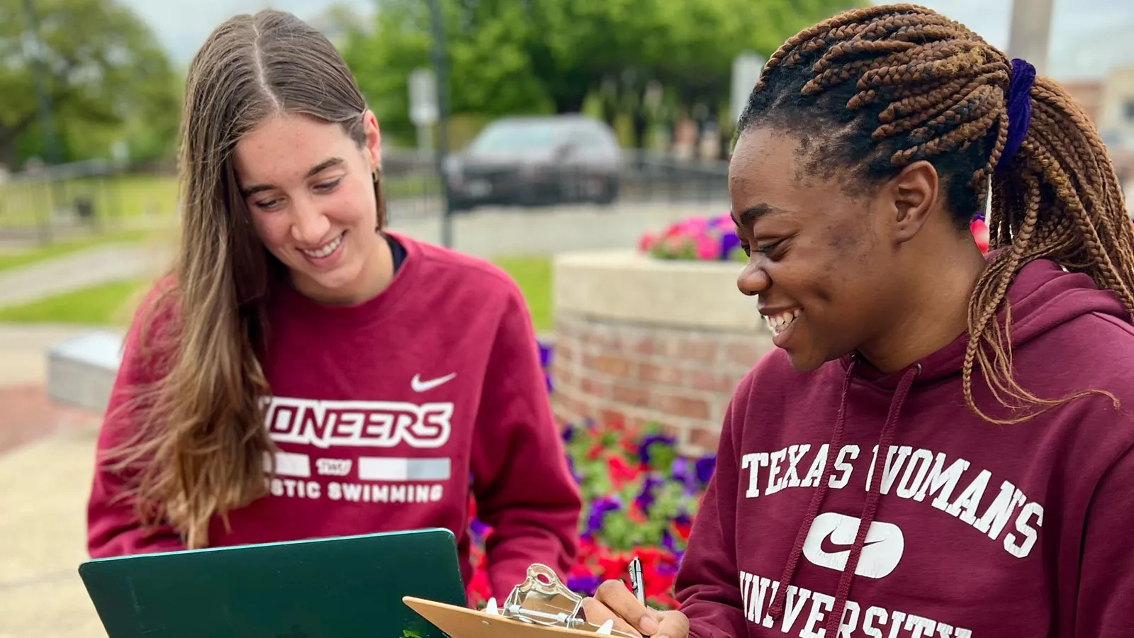 Two Honors students sit by the fountain in front of the Blagg-Huey Library on the Denton campus.