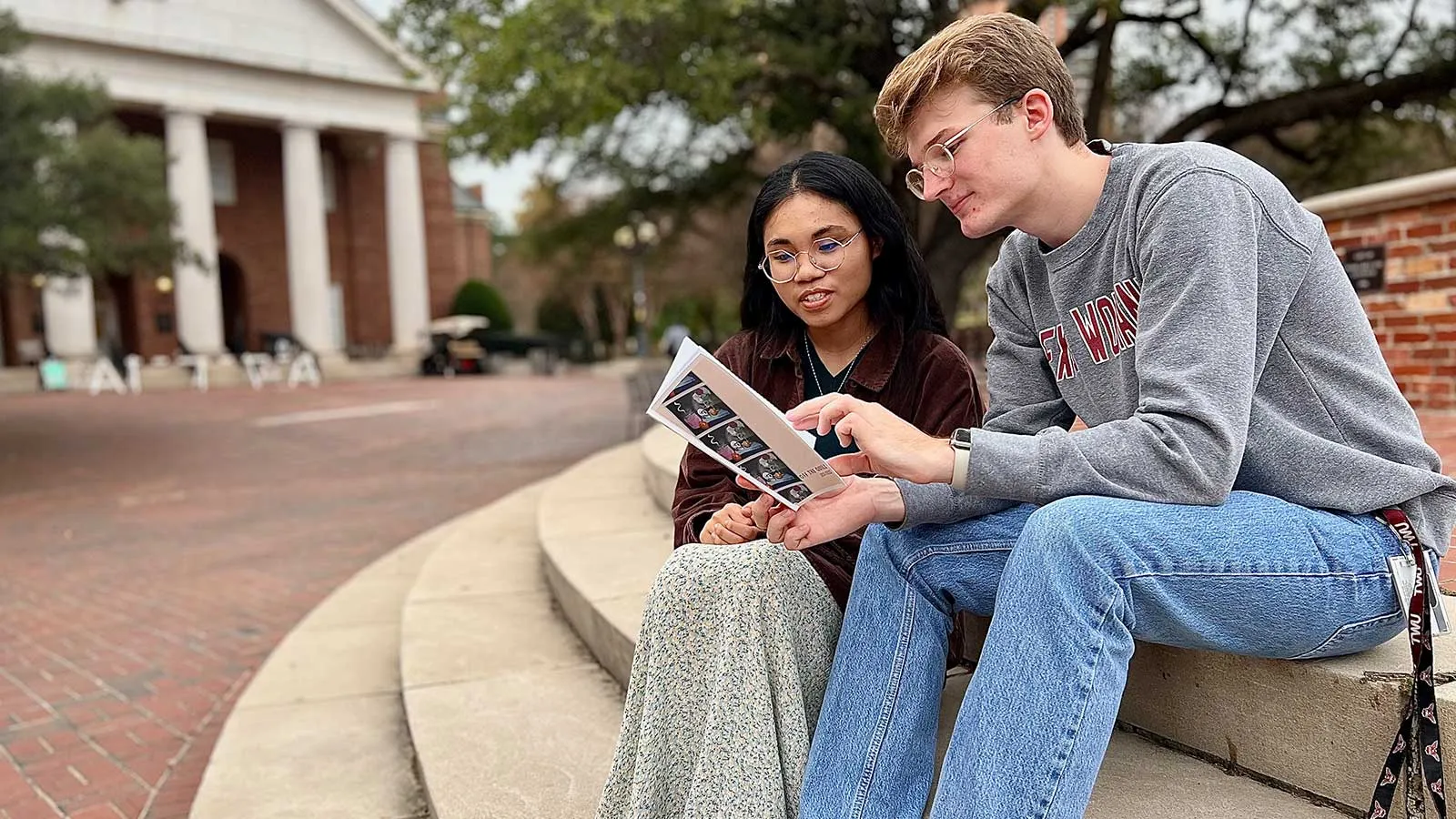 Two TWU Honors students sitting at the fountain and reading
