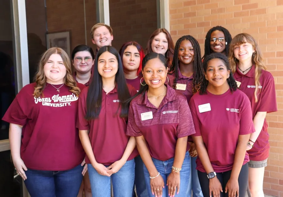 A group of students smile at camera