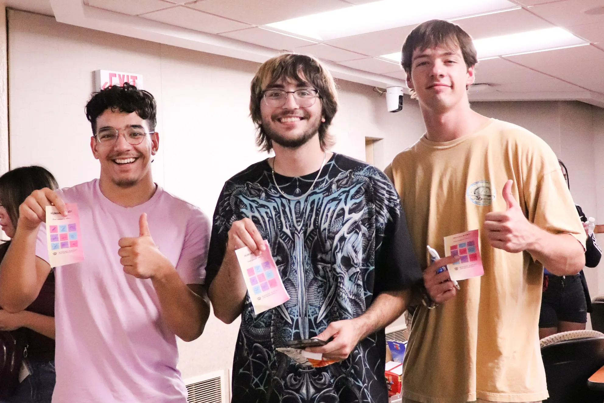 Three male students smile at camera
