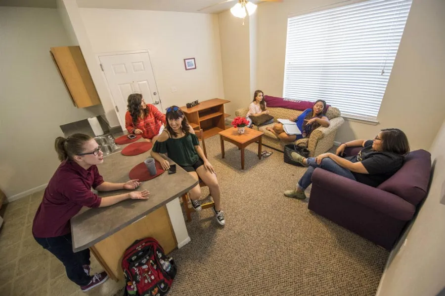 Several students in the living room of one of the Lowry Woods apartments