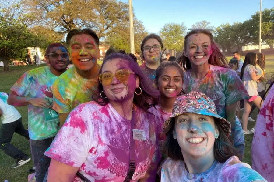5 RHA members take a selfie as they are covered in colorful powder.