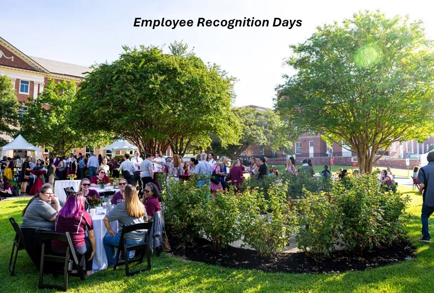 A group of staff gathered outside around tables on a beautiful spring day.