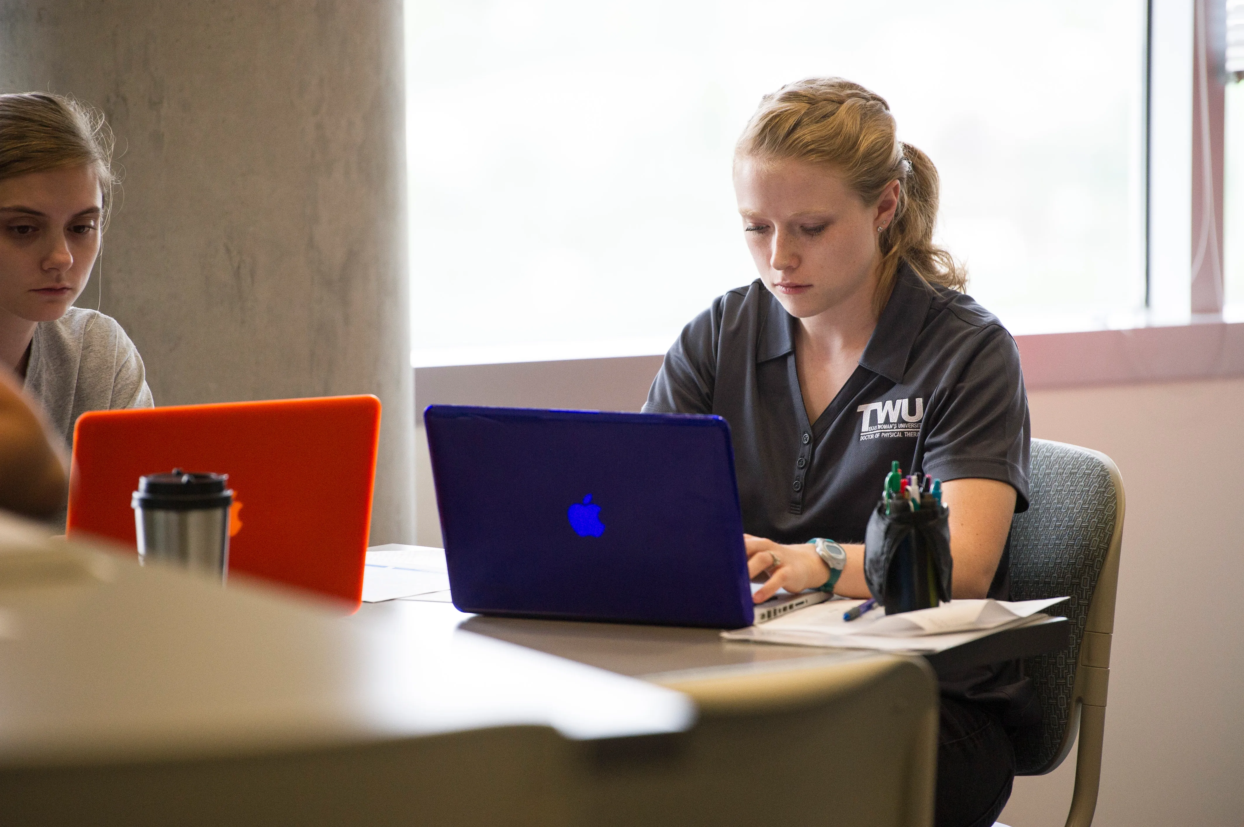 a student working on their laptop in a study space.