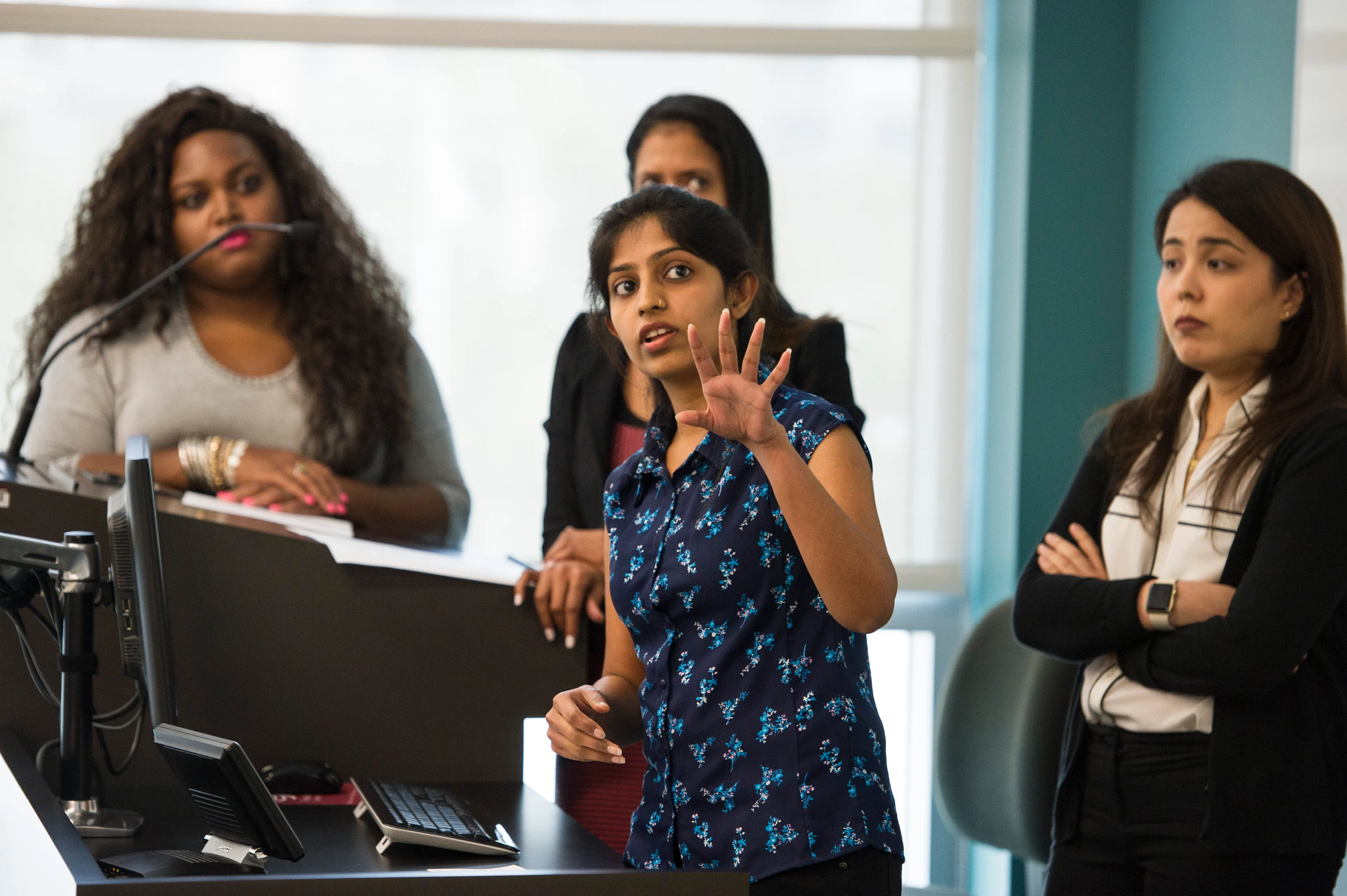 A group of young women presenting to class.