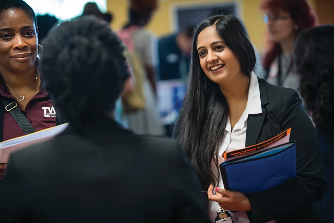 Student in business attire at a networking event