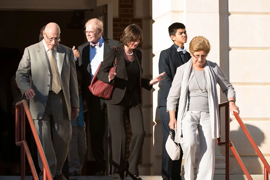Chancellor Feyten's husband Chad Wick descends the steps of the Music building with a group of people