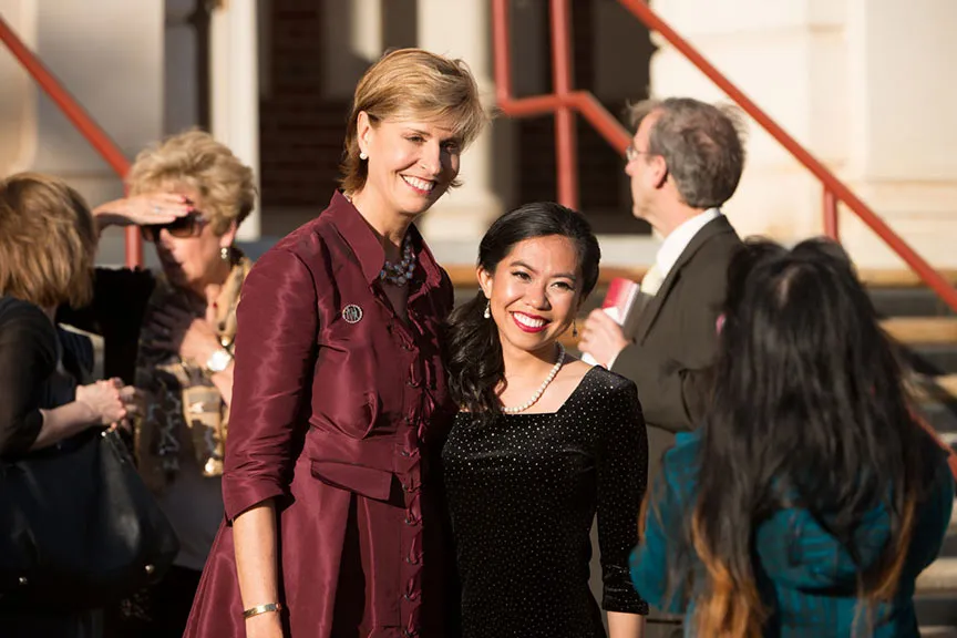 Chancellor Feyten poses for a photo with a young woman in a black dress