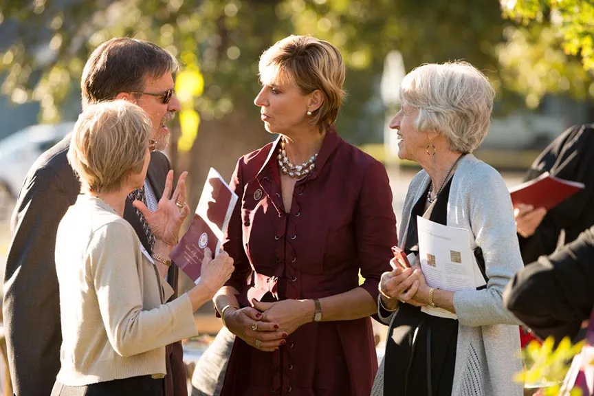Chancellor Feyten speaks with a man and two women
