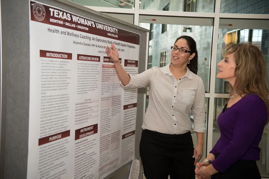 A woman explains her scientific presentation poster to an onlooker